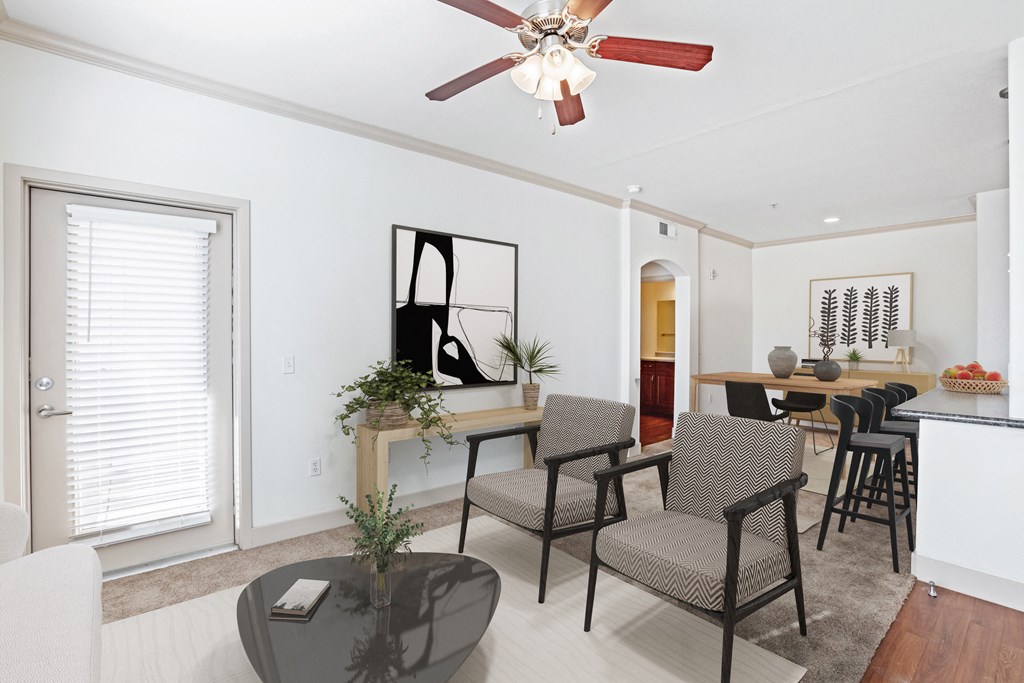 a living room with white walls and a ceiling fan