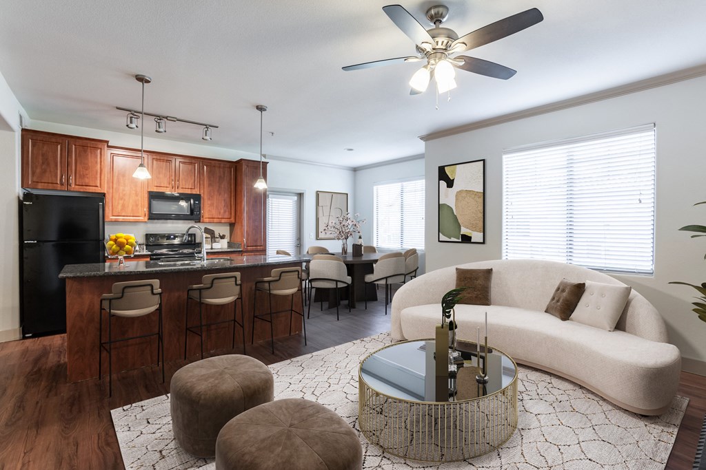 a living room and kitchen with wood cabinets and a white couch