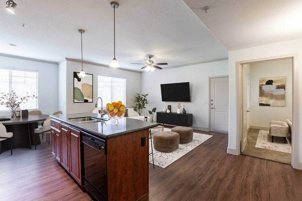 a kitchen and living room with hardwood floors and a ceiling fan
