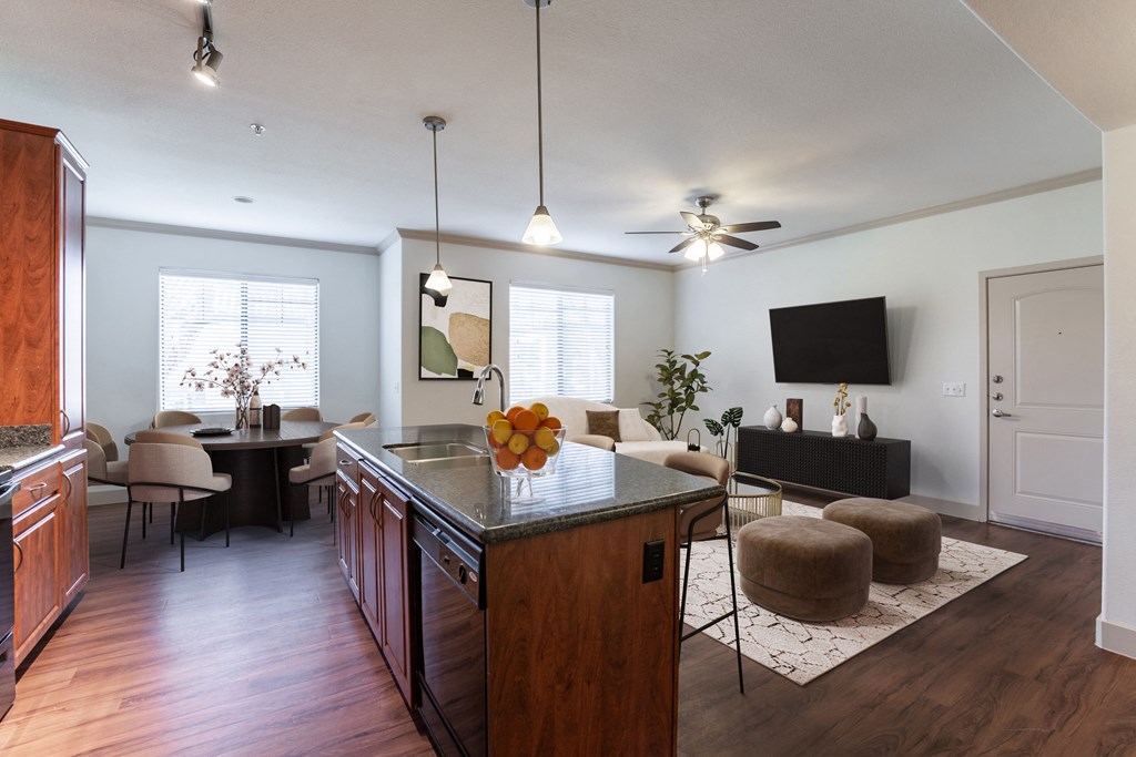 a kitchen and living room with hardwood floors and a ceiling fan