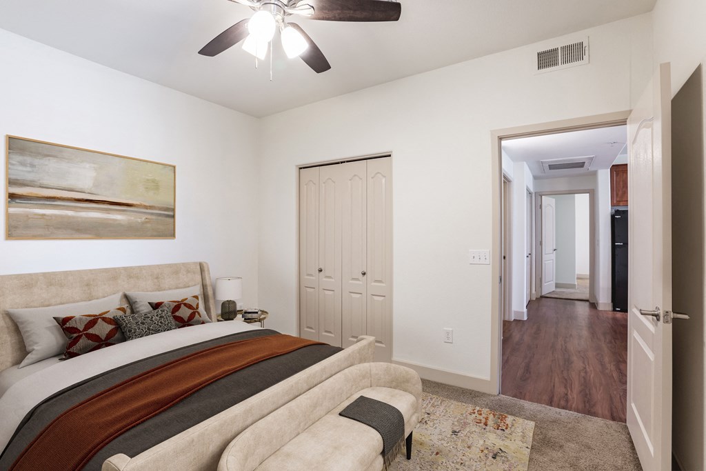 a bedroom with a large bed and a ceiling fan