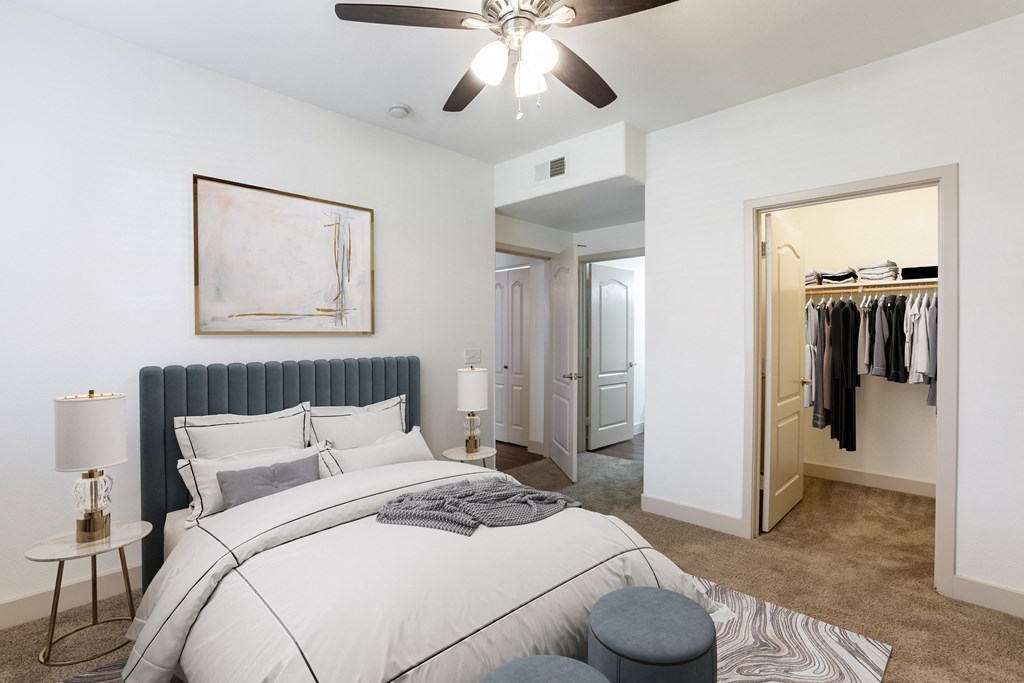 a bedroom with a large bed and a ceiling fan