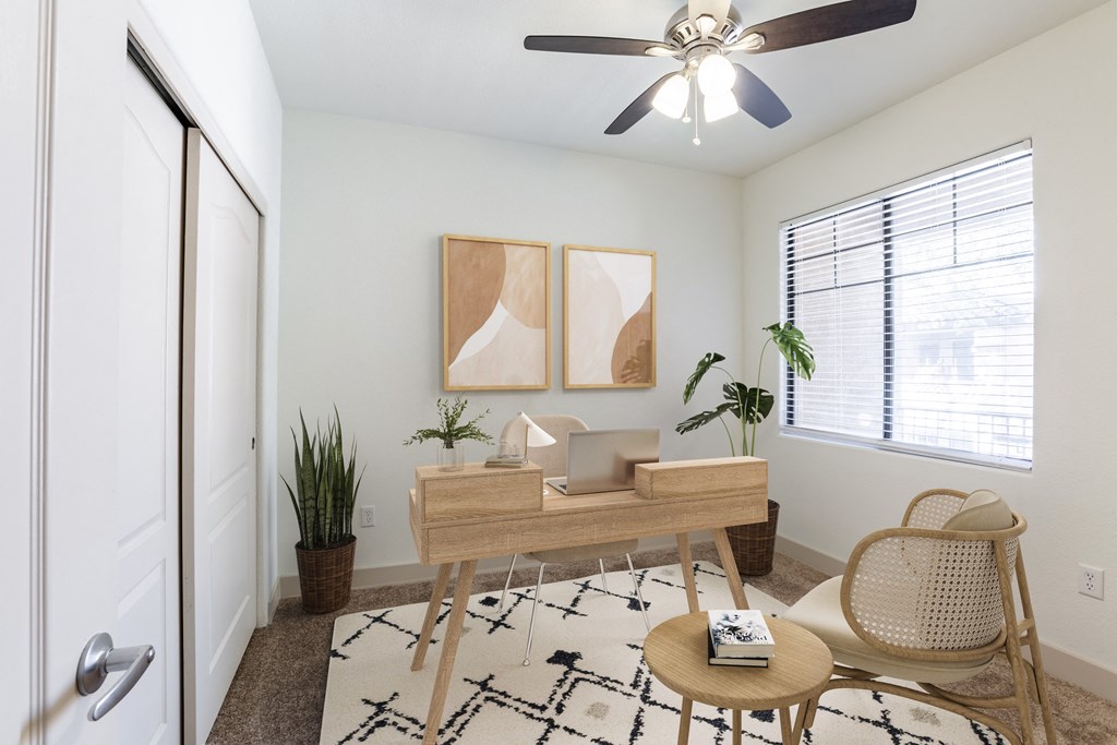 a living room with a ceiling fan and a door to a bedroom