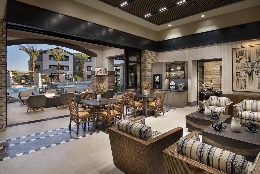 the lobby of a hotel with tables and chairs and a pool