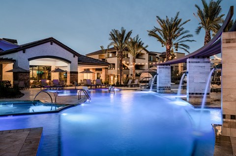 a swimming pool with blue lights at night at the resort