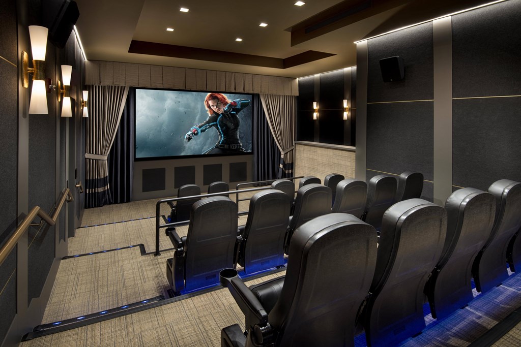 a large screening room with leather chairs and a movie screen