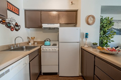 A kitchen with a white fridge and a stove top oven.