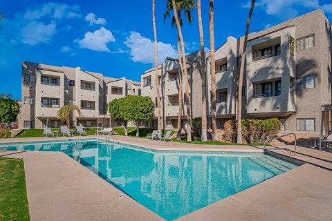 A swimming pool in front of apartment buildings.