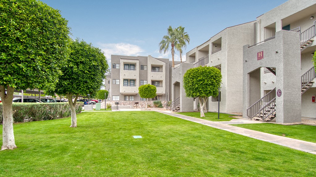 El Encanto outside view with nice lush grass area with trees around