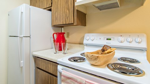 A white refrigerator is next to a white stove in a kitchen.
