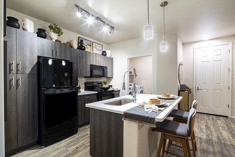 a kitchen with a large island and black appliances