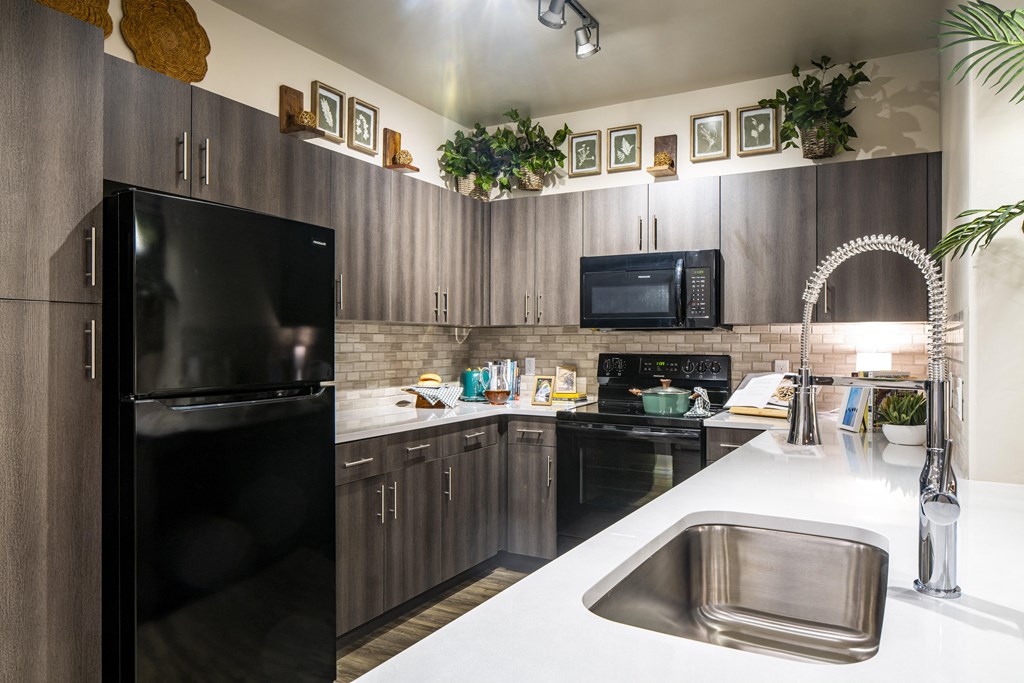 a kitchen with black appliances and white countertops