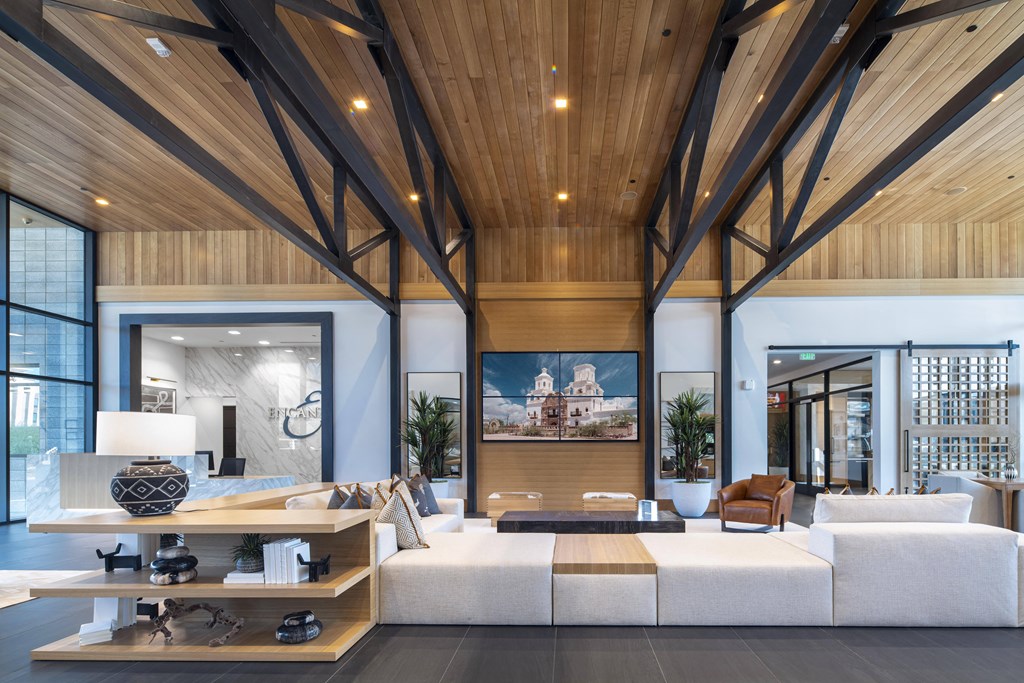 a living room with a large white couch and wooden ceilings