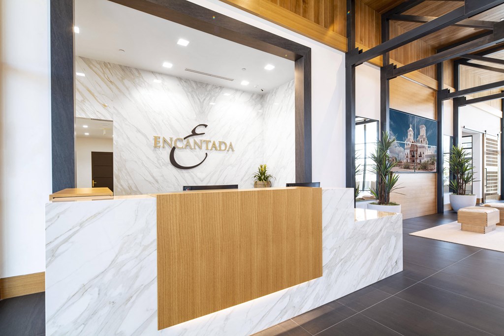 a reception area with a marble reception desk and a logo