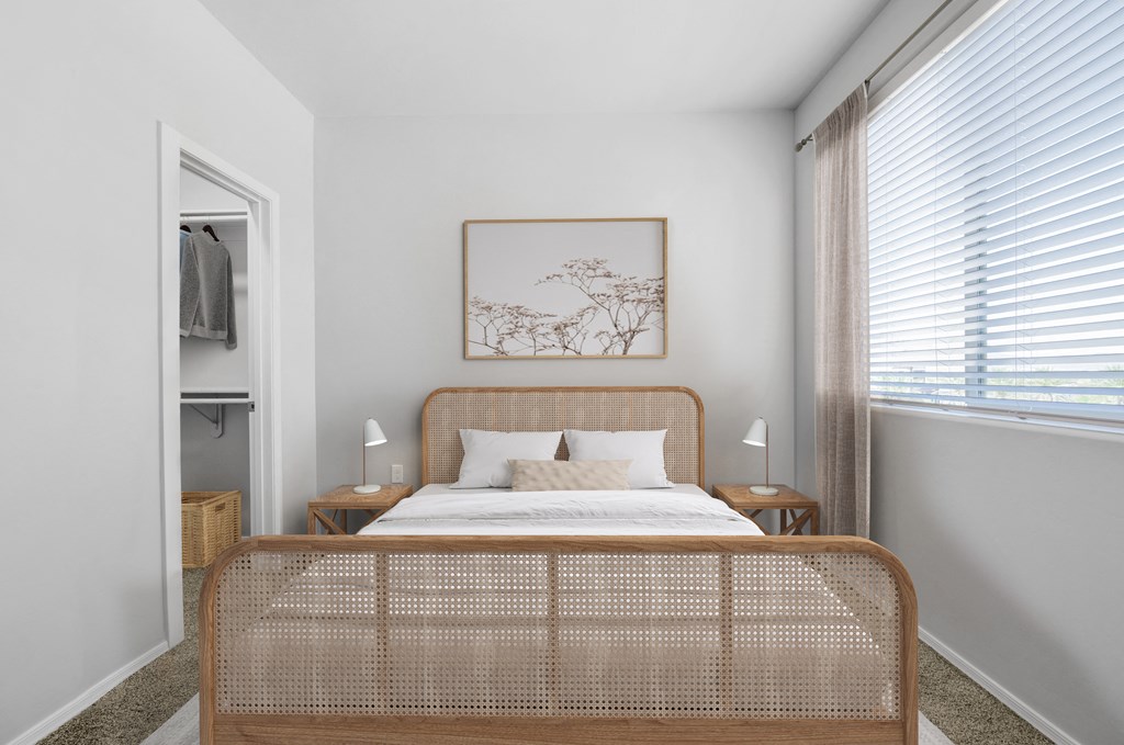 a bedroom with a large window and a bed with a rattan headboard