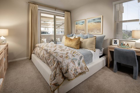 A bedroom with a large bed and a window with curtains.