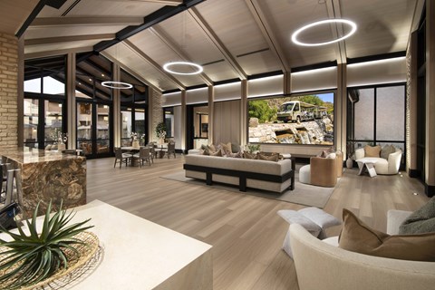 A modern living room with a large sofa and a TV on the wall.