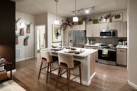 A kitchen with a table and chairs in front of a refrigerator.