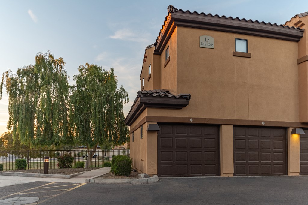 a house with a garage and a weeping willow tree in the background