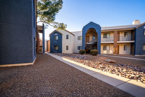 A row of modern houses with a gravel driveway in between.