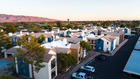 A sunset view of a neighborhood with houses and cars.
