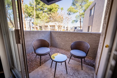 A patio with two chairs and a table.