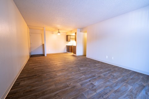 A room with wooden flooring and white walls.