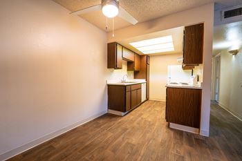 A kitchen with wooden floors and white walls.