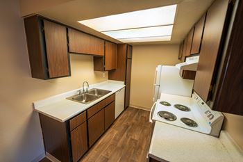 A small kitchen with a stove top oven and a sink.