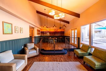 A living room with a sofa, chairs, and a rug.