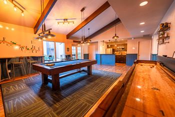 A room with a pool table and a billiard table.