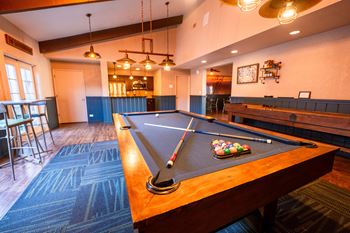 A pool table with a blue cloth and a set of pool balls on it.