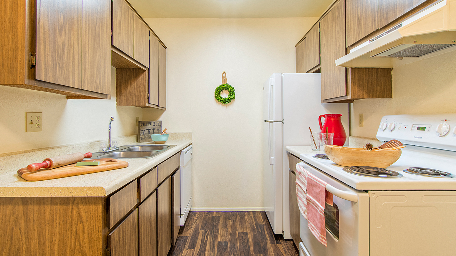 a kitchen with a stove sink and refrigerator   and wooden cabinets