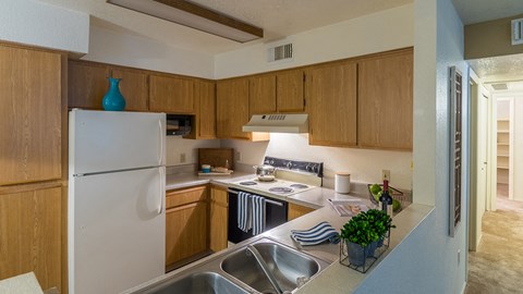 Estancia kitchen with plenty of cabinetry, a fridge, stove, and a sink