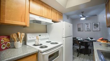 A kitchen with a stove, refrigerator, and dining table.