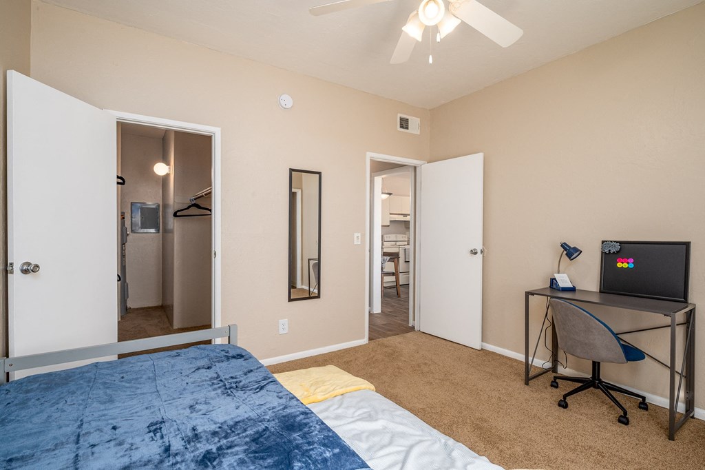 a bedroom with a large bed and a desk with a tv