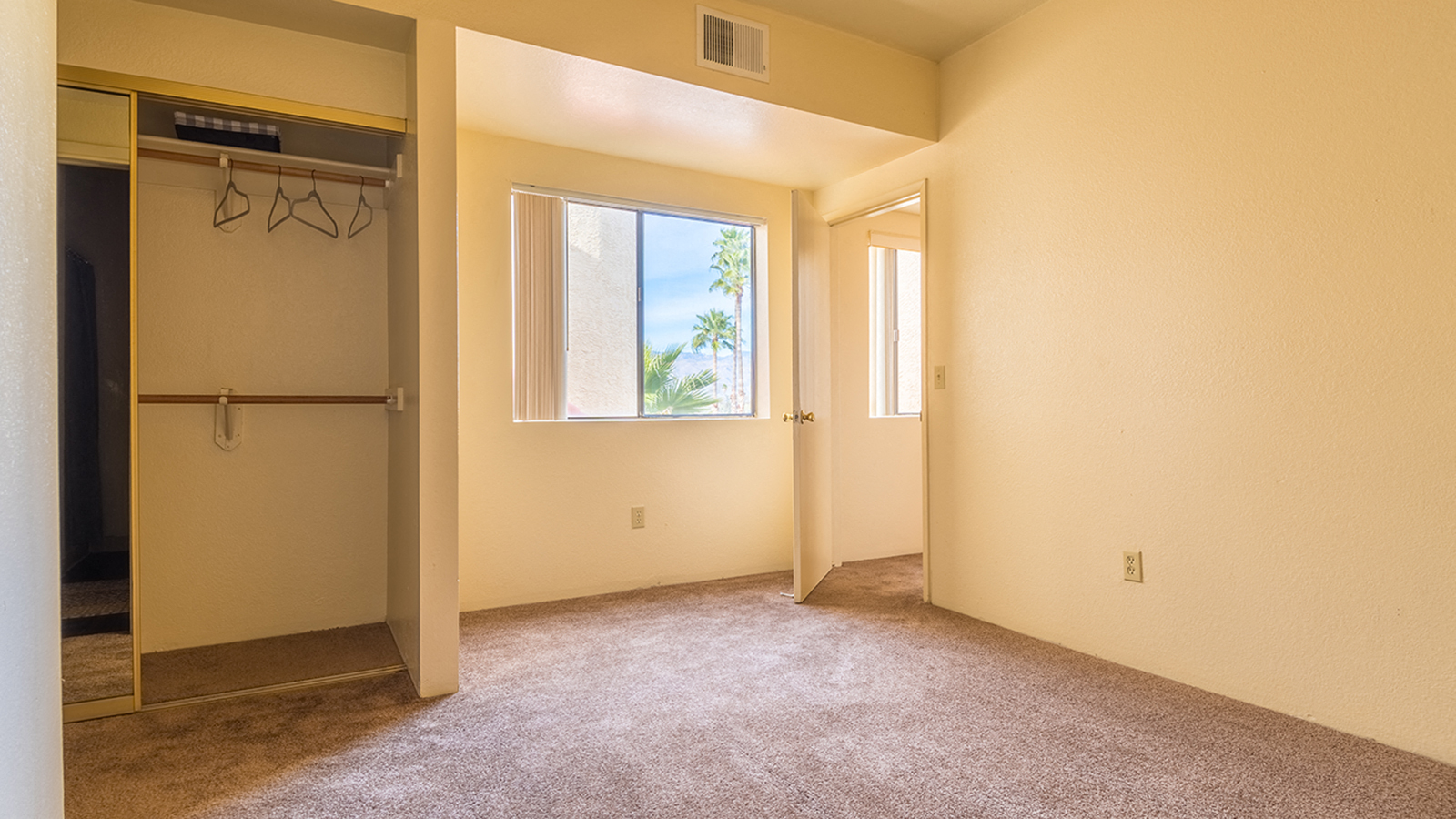 bedroom with large window and closet with mirror