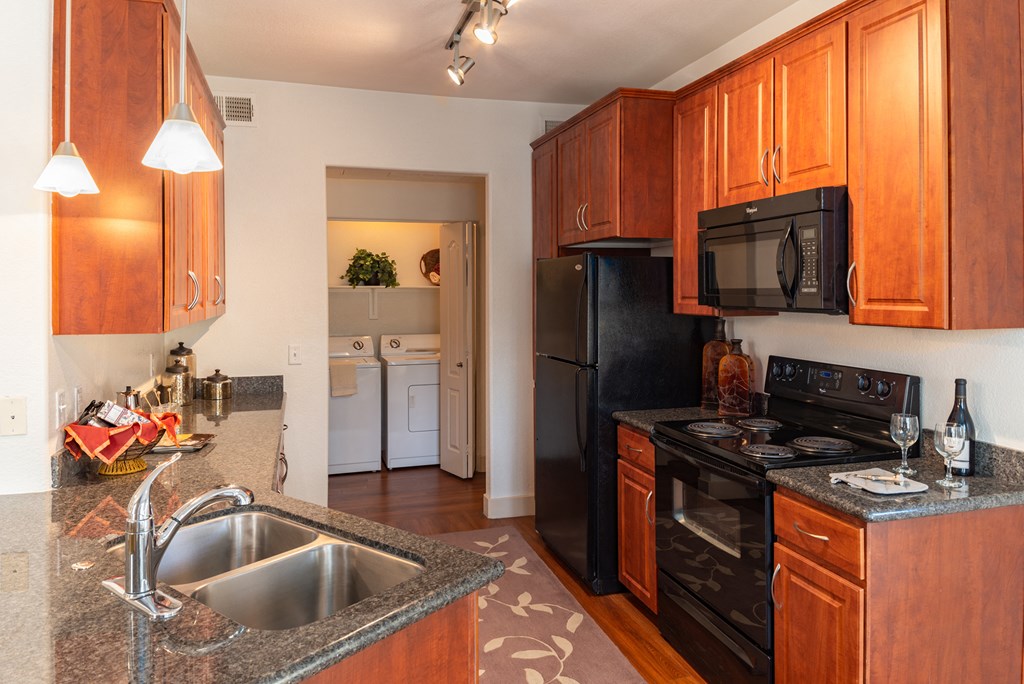 a kitchen with wood cabinets and black appliances