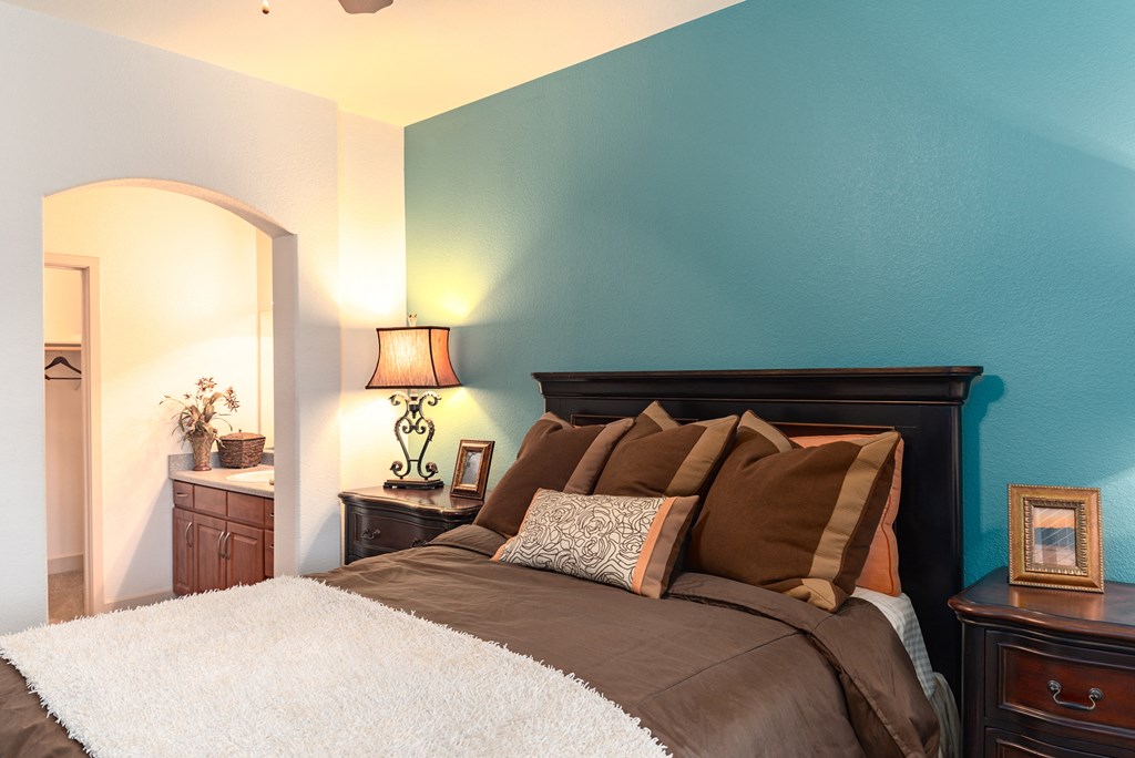 a bedroom with a bed and a nightstand with a lamp