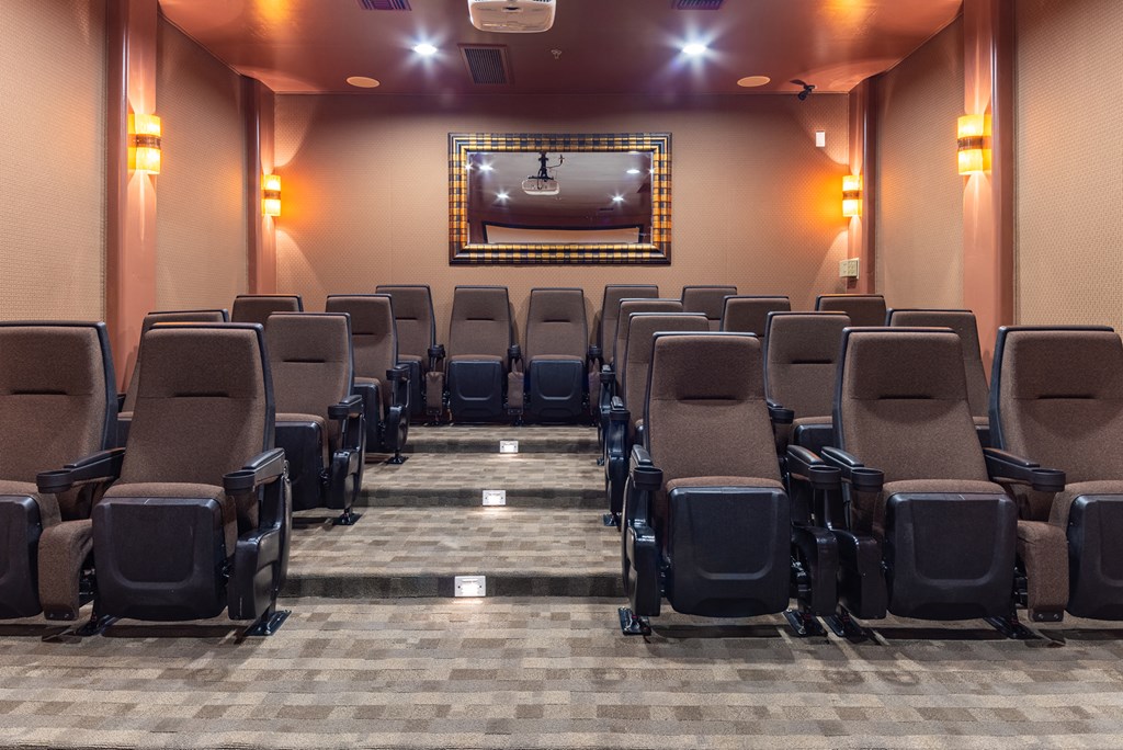 a large auditorium with chairs and a projector screen