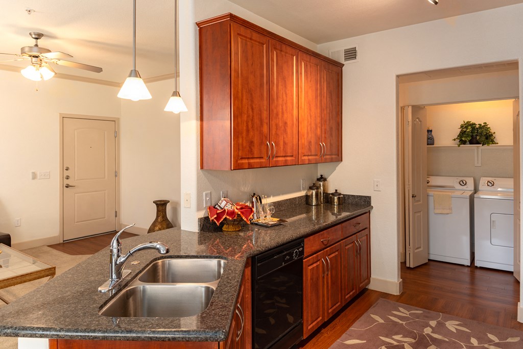 a kitchen with granite countertops and wooden cabinets