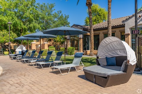 A row of lounge chairs are arranged on a patio.