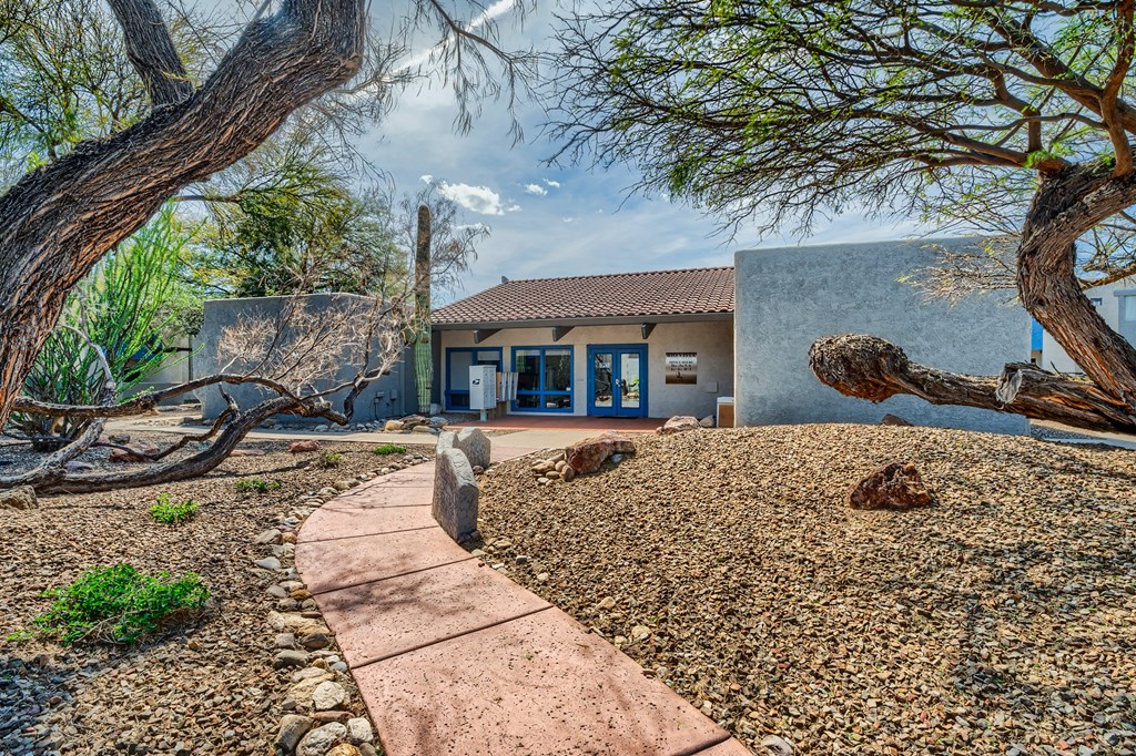 a house with a pathway and trees in front of it
