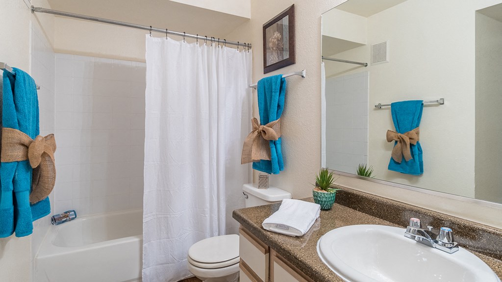 Cantera bathrooms with vanity sinks and shower tub combo