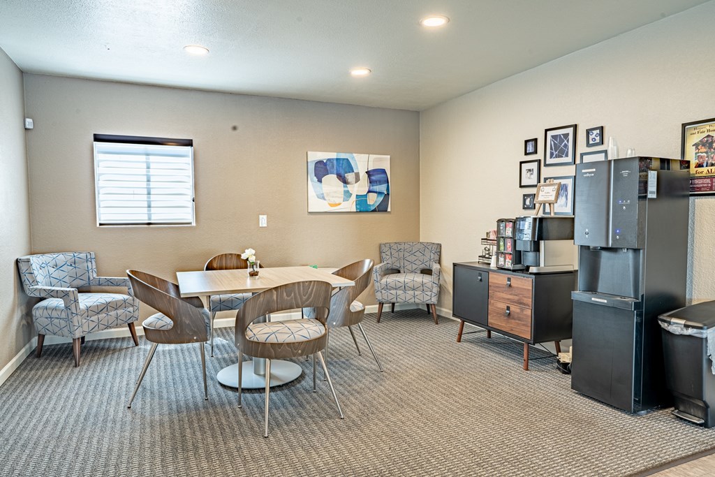 a living room with a table and chairs and a refrigerator