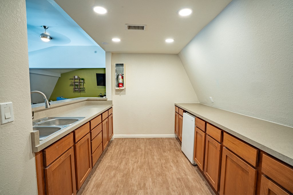 a kitchen with wooden cabinets and a sink and a mirror