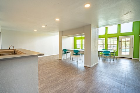 an open living room with a kitchen and dining area with green walls and windows
