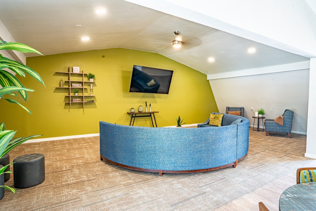 a reception area with a yellow wall and blue furniture