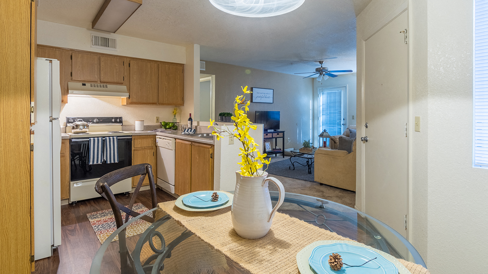 a kitchen and dining room with a table and a vase with flowers