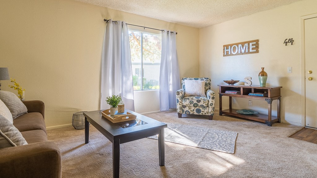 The Springs spacious living room with nice natural lighting and carpet flooring